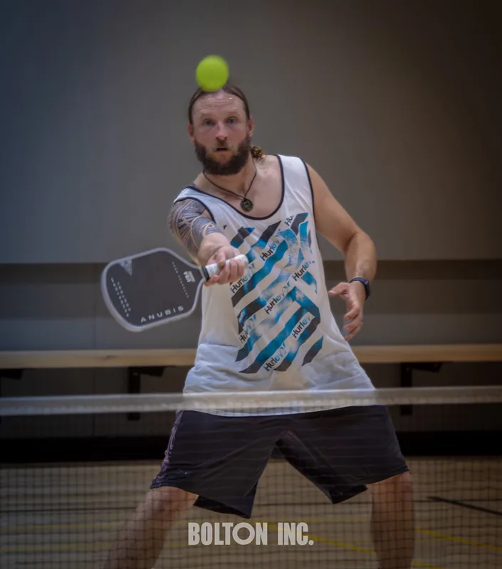 Pickleball player preparing to return a ball indoors